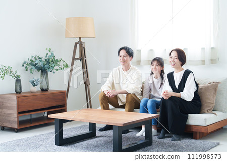 Parents and children watching TV in the living room Parents and children watching TV in the living room 111998573