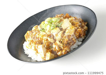 一張白色背景下熱騰騰的麻婆碗的照片，上面放著大量的豆腐和蔥 111999475