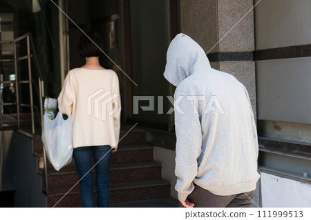 Suspicious person stalking a woman 111999513