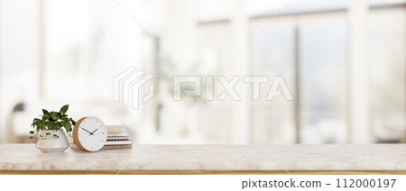 A luxury white marble tabletop with a copy space with a blurred background of a bright living room. 112000197