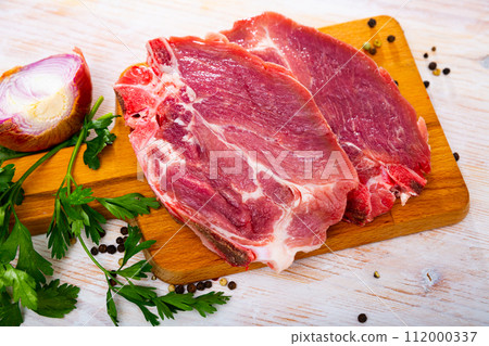 Sliced raw pork chop with parsley and onion 112000337