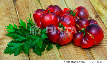 Close-up of fresh brown tomatoes on wooden surface Close-up of fresh brown tomatoes on wooden surface 112000340