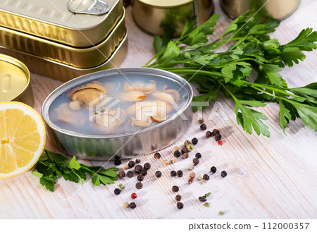 Tin can with sea shellfish in its own juice, closeup 112000357