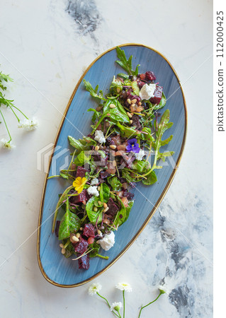 top view organic baby greens salad with beetroot, goat cheese, pistachios and citrus dressing top view organic baby greens salad with beetroot, goat cheese, pistachios and citrus dressing 112000425