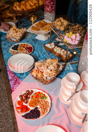 top view of Kazakhstani treats. Delicious pastries and nuts on a blue velvet tablecloth. top view of Kazakhstani treats. Delicious pastries and nuts on a blue velvet tablecloth. 112000426
