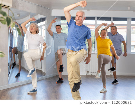 Elderly man learning dynamic dances at group choreography lesson Elderly man learning dynamic dances at group choreography lesson 112000681