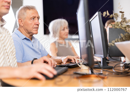 Old man learning computer programs in training room 112000767