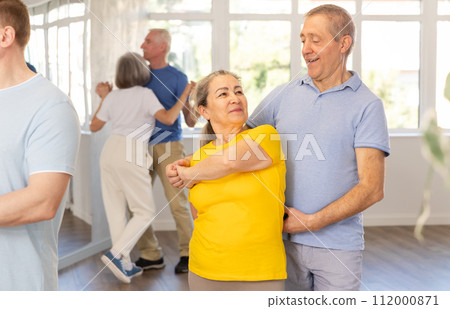 Elderly woman with male partner in latin dance class. Social dancing concept 112000871