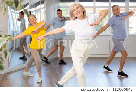 Group of aged people rehearsing sports dance in dance class Group of aged people rehearsing sports dance in dance class 112000945