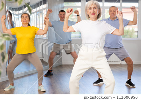 Elderly woman dances modern dances in group 112000956