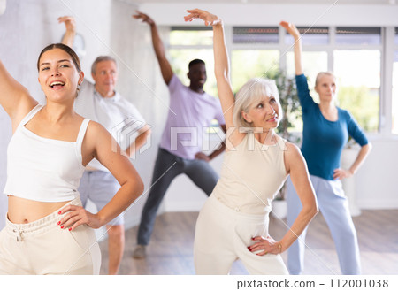 Female instructor teaches senior students of different ages basic movements of contemporary dances Female instructor teaches senior students of different ages basic movements of contemporary dances 112001038