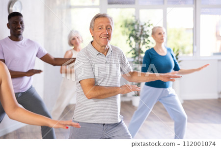 Elderly retired man dancing hip hop in studio practicing dance number. Elderly retired man dancing hip hop in studio practicing dance number. 112001074