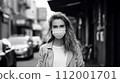 Young woman wearing a mask outdoors 112001701