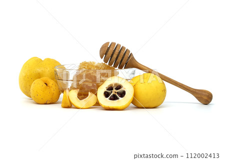 Bright golden-yellow quince fruits and honey on white 112002413
