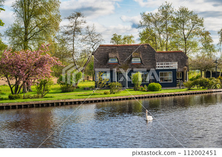 Giethoorn Netherlands, city skyline at canal and traditional house in Giethoorn village 112002451