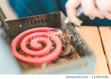 A camper lights up a mosquito coil 112003886