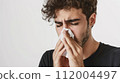 Foreign man blowing his nose 112004497