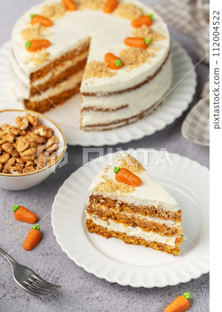Homemade carrot cake made with walnuts, iced with cream cheese. Sweet dessert. Homemade carrot cake made with walnuts, iced with cream cheese. Sweet dessert. 112004522