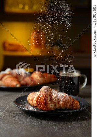 Croissants sprinkled with sugar powder. 112005603