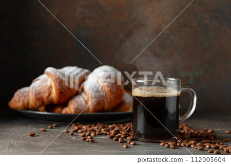 Croissants and black coffee on a kitchen table. 112005604