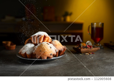 Homemade raisin cupcakes sprinkled with powdered sugar. 112005608