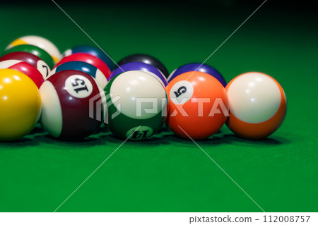 Many colorful billiard balls on green table 112008757