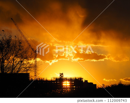 公寓建築工地和沐浴在夕陽下的起重機 112009743