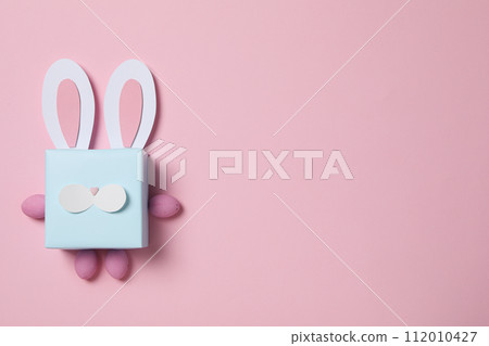 Blue gift box with rabbit ears on pink background Blue gift box with rabbit ears on pink background 112010427