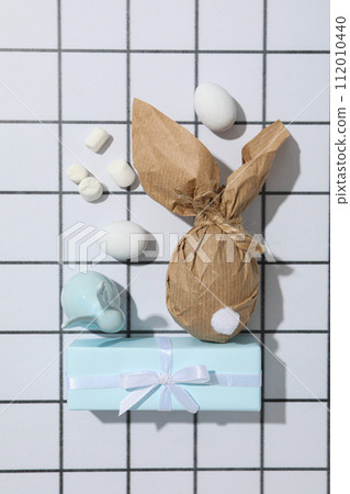 Chocolate egg wrapped with gifts on a light background 112010440