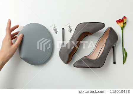Accessories, female hand, shoes and flower on white background, top view 112010458