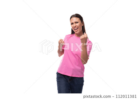 young joyful confident brunette woman in a pink basic t-shirt on a white background with copy space young joyful confident brunette woman in a pink basic t-shirt on a white background with copy space 112011381