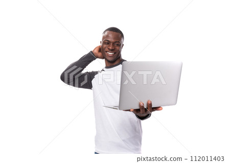 young african guy with short haircut is using laptop for remote work young african guy with short haircut is using laptop for remote work 112011403
