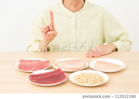 Middle-aged woman with protein-rich ingredients and index finger up 112012190