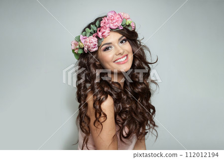 Cheerful woman with make-up, perfect white toothy smile and spring or summer season rose wreath Cheerful woman with make-up, perfect white toothy smile and spring or summer season rose wreath 112012194