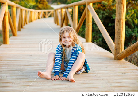 Happy cheerful teenager standing on beach at sunset. happy preteen boy smiling at the camera. Kid on family vacation at the sea. 112012656