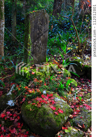 Old stone monument and fallen autumn leaves Old stone monument and fallen autumn leaves 112012801