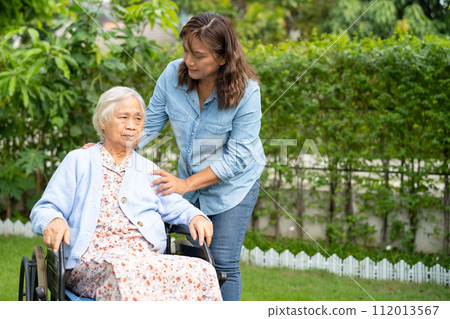 Caregiver help and care Asian senior woman patient sitting on wheelchair at nursing hospital ward, healthy strong medical. Caregiver help and care Asian senior woman patient sitting on wheelchair at nursing hospital ward, healthy strong medical. 112013567