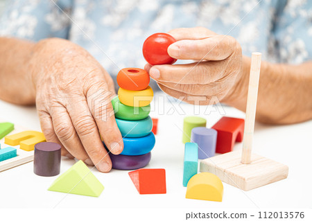 Alzheimer disease AD, Asian elderly woman patient suffering from dementia learn practical motor skills rehabilitation. Alzheimer disease AD, Asian elderly woman patient suffering from dementia learn practical motor skills rehabilitation. 112013576