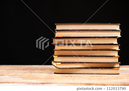 Stack of old books on a black background. Wisdom and knowledge, love of reading. Stack of old books on a black background. Wisdom and knowledge, love of reading. 112013790