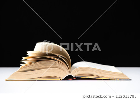 Pages of a thick book are turned on a white and black background, space for text. 112013793