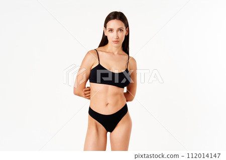 Beautiful sensual slim woman in black underwear on white studio background 112014147
