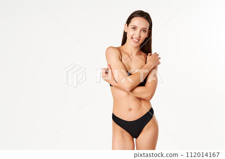Pretty smiling woman in black underwear posing on white studio background Pretty smiling woman in black underwear posing on white studio background 112014167