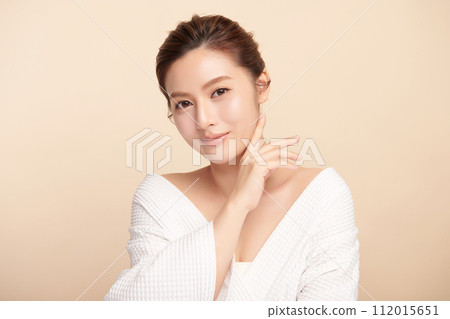 Beautiful young asian woman with clean fresh skin on beige background, Face care, Facial treatment, Cosmetology, beauty and spa, Asian women portrait. Beautiful young asian woman with clean fresh skin on beige background, Face care, Facial treatment, Cosmetology, beauty and spa, Asian women portrait. 112015651