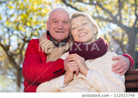 Mature couple sitting in park 112015749