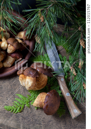 Imleria Badia or Boletus badius mushrooms commonly known as the bay bolete, clay bowl with mushrooms and knife on vintage wooden background.. Imleria Badia or Boletus badius mushrooms commonly known as the bay bolete, clay bowl with mushrooms and knife on vintage wooden background.. 112015767