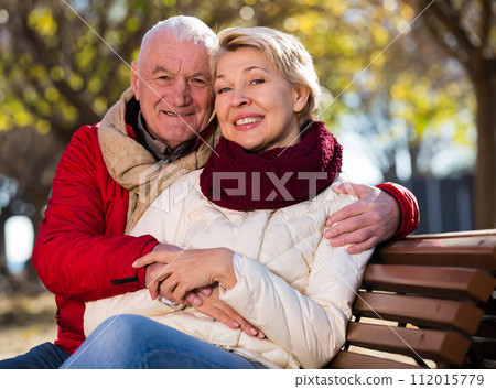 Mature couple sitting in park 112015779