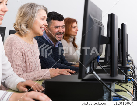 Side view of coworkers during daily work at computers in office 112016004