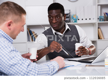 Interracial two male in the office filling up documents 112016085