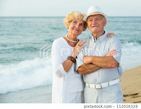 happy pensioners woman and man on the beach 112016328