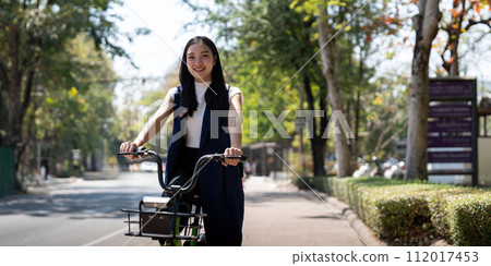 Eco friendly, Happy lifestyle asian beautiful young businesswoman riding bicycle go to office work at city street with bicycle in morning Eco friendly, Happy lifestyle asian beautiful young businesswoman riding bicycle go to office work at city street with bicycle in morning 112017453